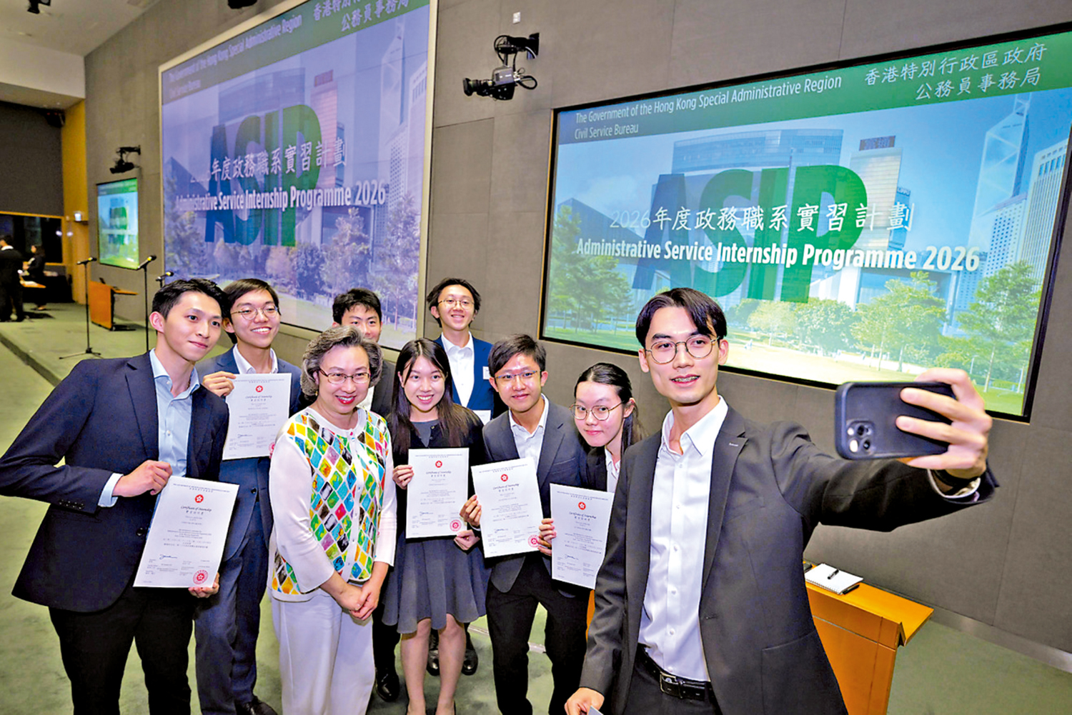 　　圖：楊何蓓茵向參加政務職系實習計劃的大學生頒發實習證明書後合照。\政府新聞處