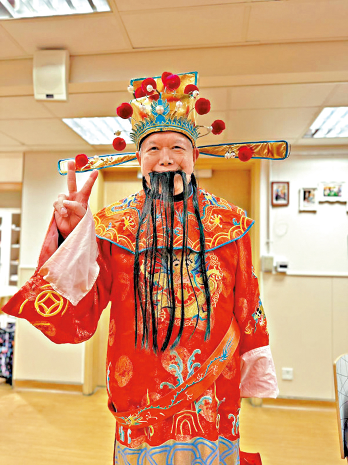 　　圖：患有阿茲海默症的謝生，在社區中心主動參與活動，早前扮演財神向好友送上新年祝福。\聖雅各福群會提供