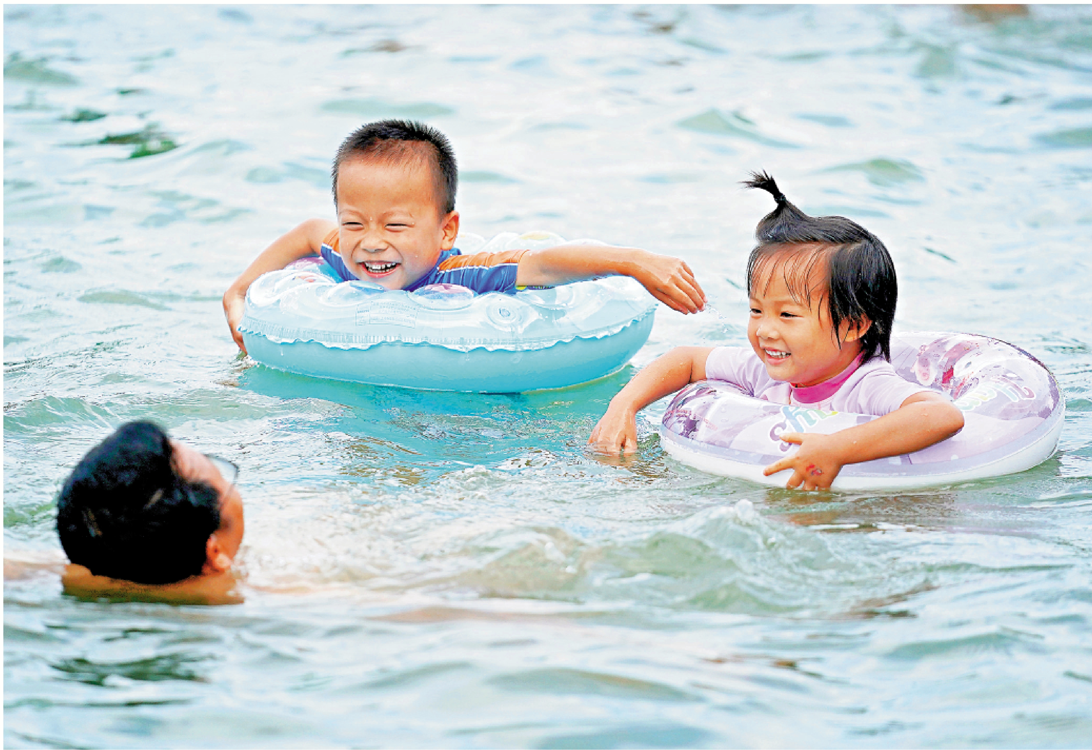 　　圖：孩子們和家長在泳池內游泳戲水。\新華社