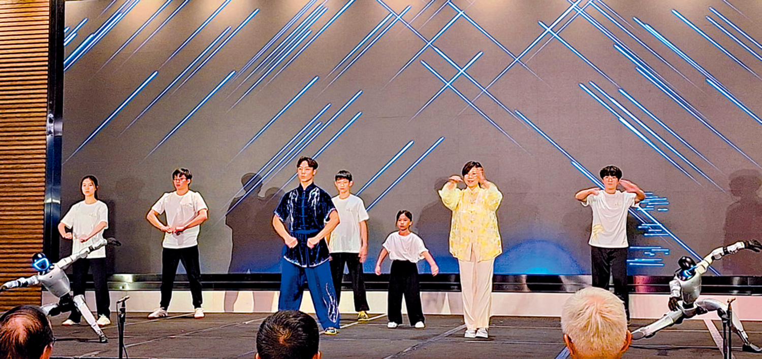 　　圖：兩位機械人與太極師傅李暉及其弟子一同表演。\作者供圖