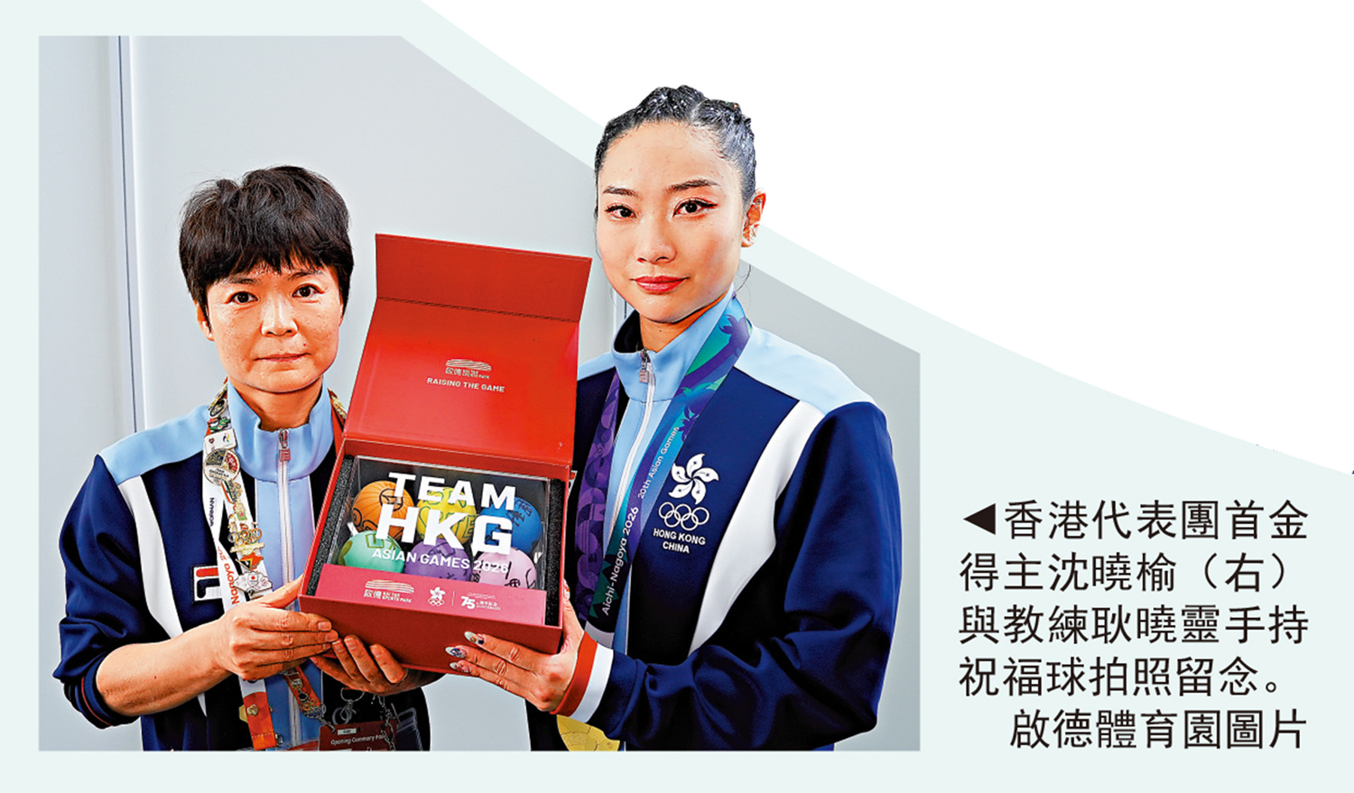 　　圖：香港代表團首金得主沈曉榆（右）與教練耿曉靈手持祝福球拍照留念。\啟德體育園圖片