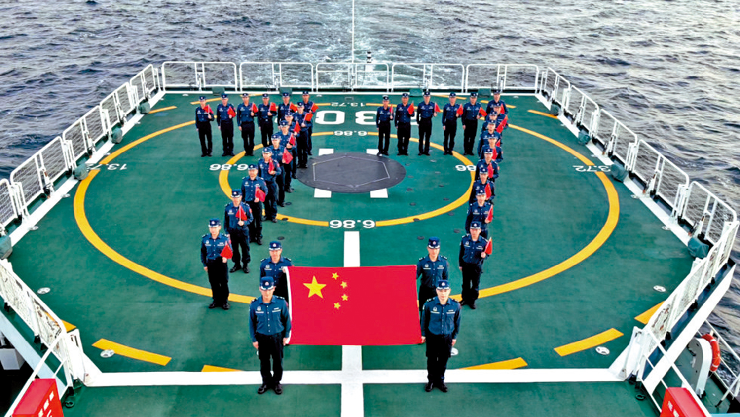 　　圖：10月1日上午，中國海警萬山艦執法員在黃岩島海域展示國旗，慶祝國慶。\中國海警圖片