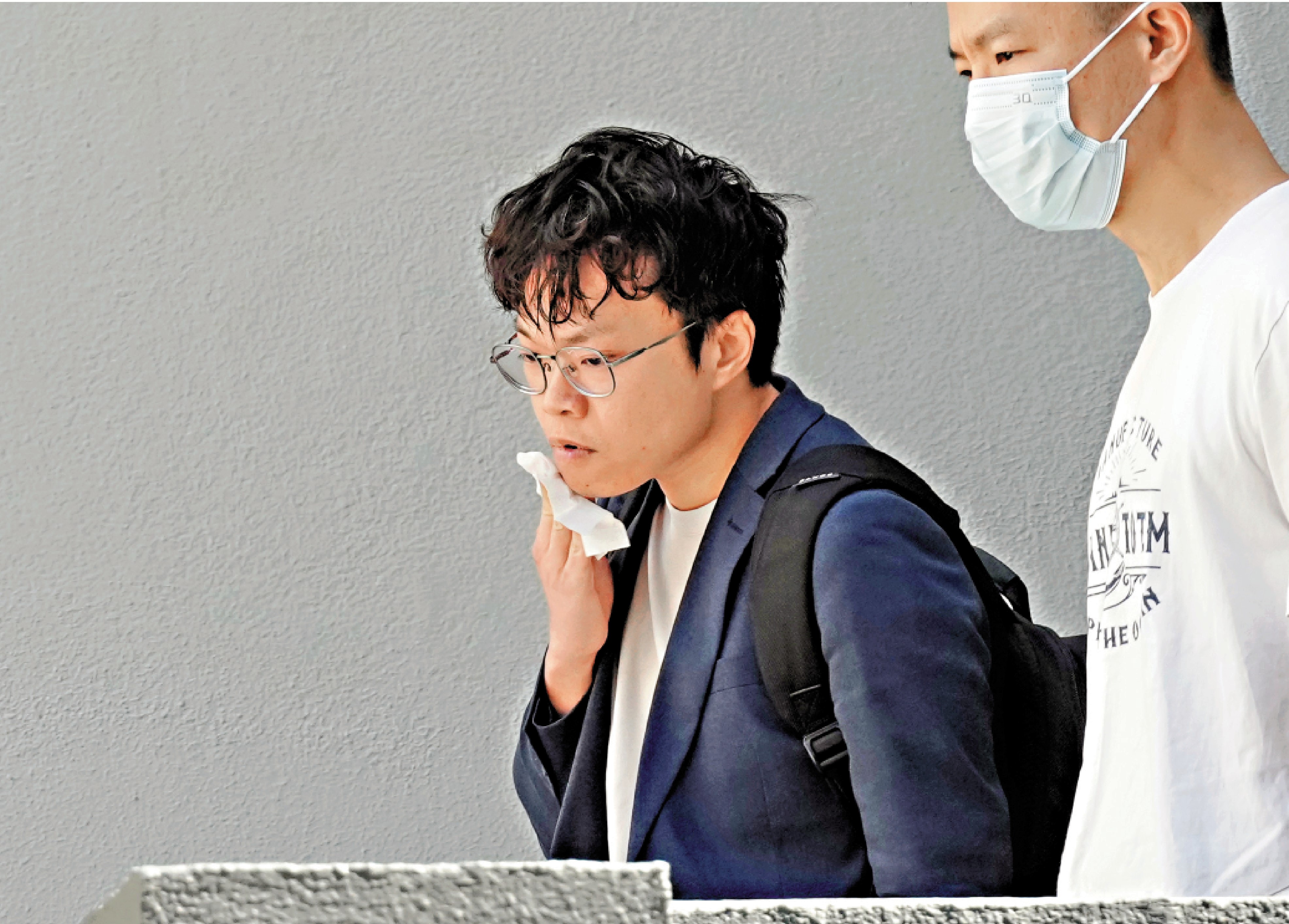 　　圖：黃嘉浩（左）昨日離開警署時，神色凝重。\大公報記者攝