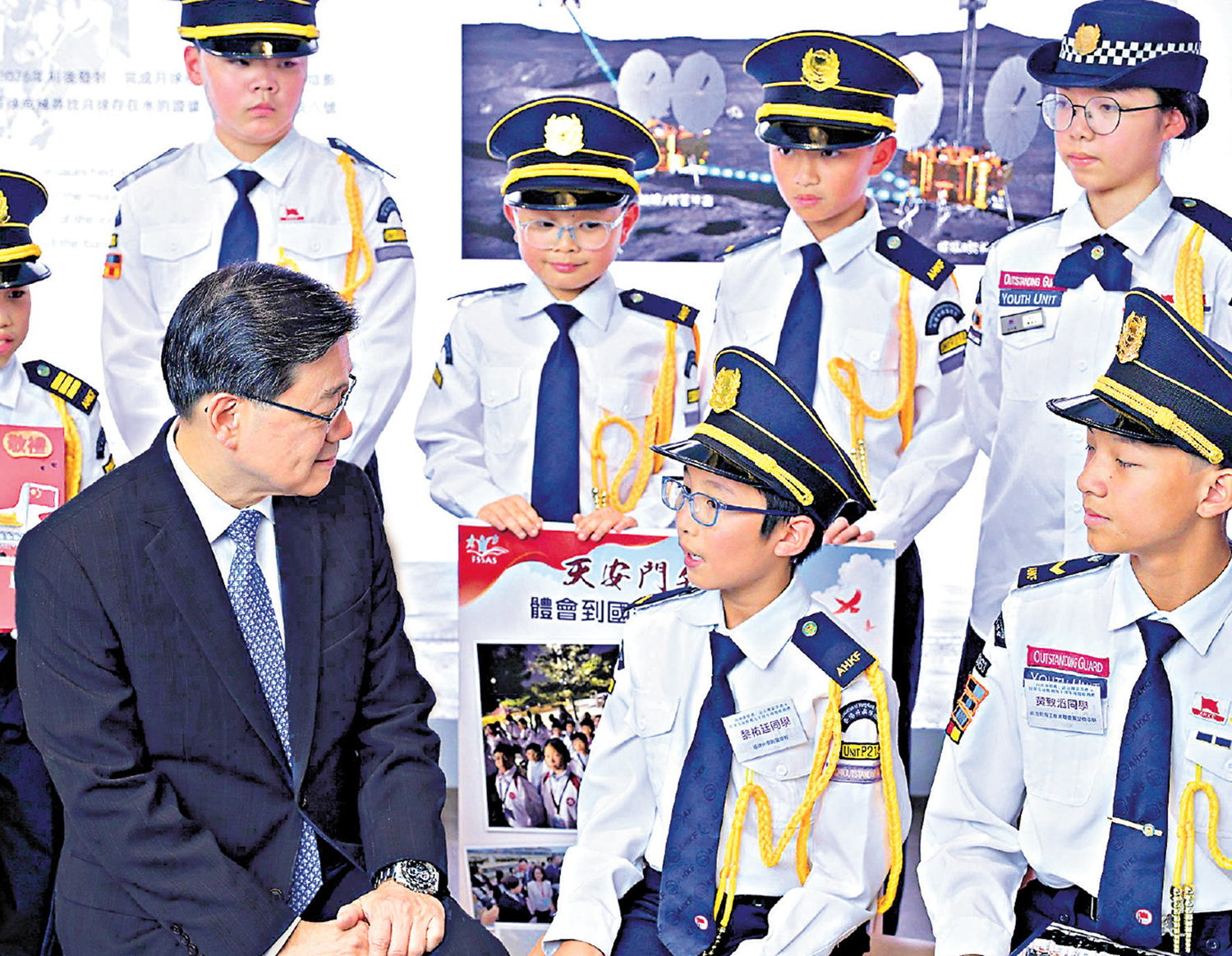 　　圖：行政長官李家超聽取港澳青少年升旗隊代表訪京團成員分享學習成果。\政府新聞處