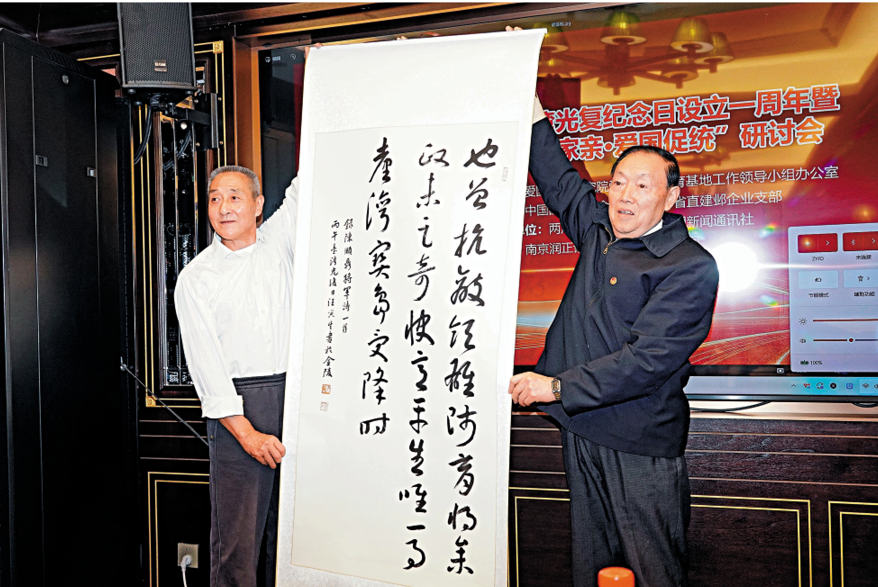 　　圖：江蘇省直書法家協會名譽主席汪寅生向陳頤鼎將軍之子陳萬中（左）贈送書法作品。\大公報記者賀鵬飛攝