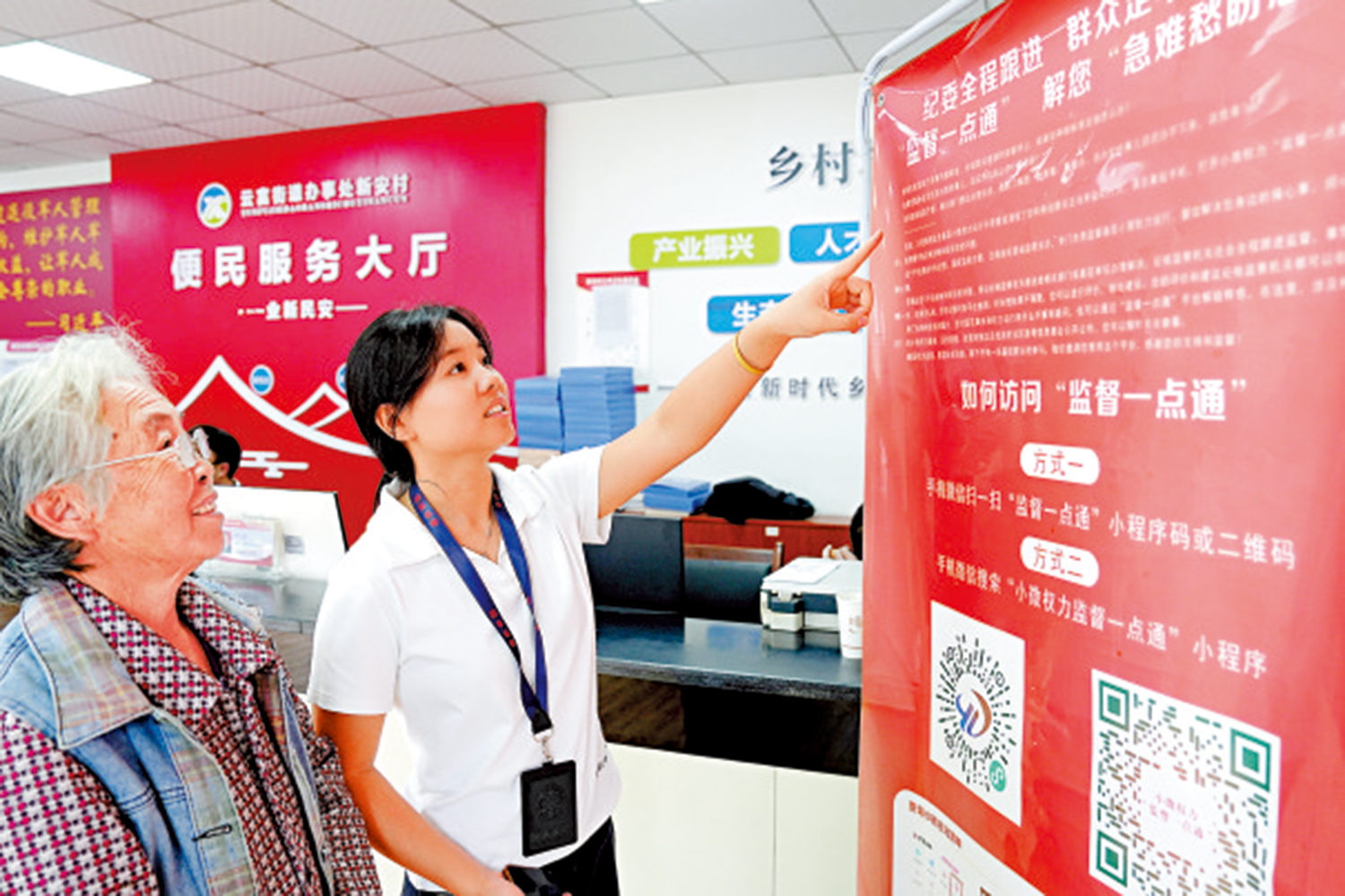 　　圖：雲南省水富市紀檢監察幹部向村民介紹「監督一點通」平台掃碼使用方法。\新華社