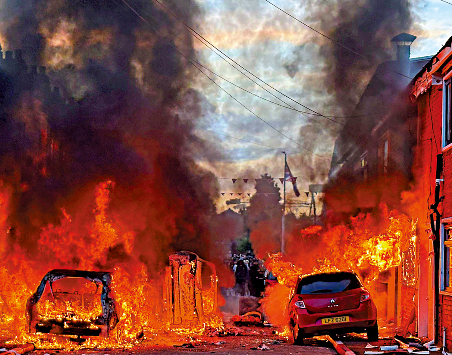 　　圖：貝爾法斯特今年6月爆發反移民騷亂，街邊的汽車遭縱火。\美聯社