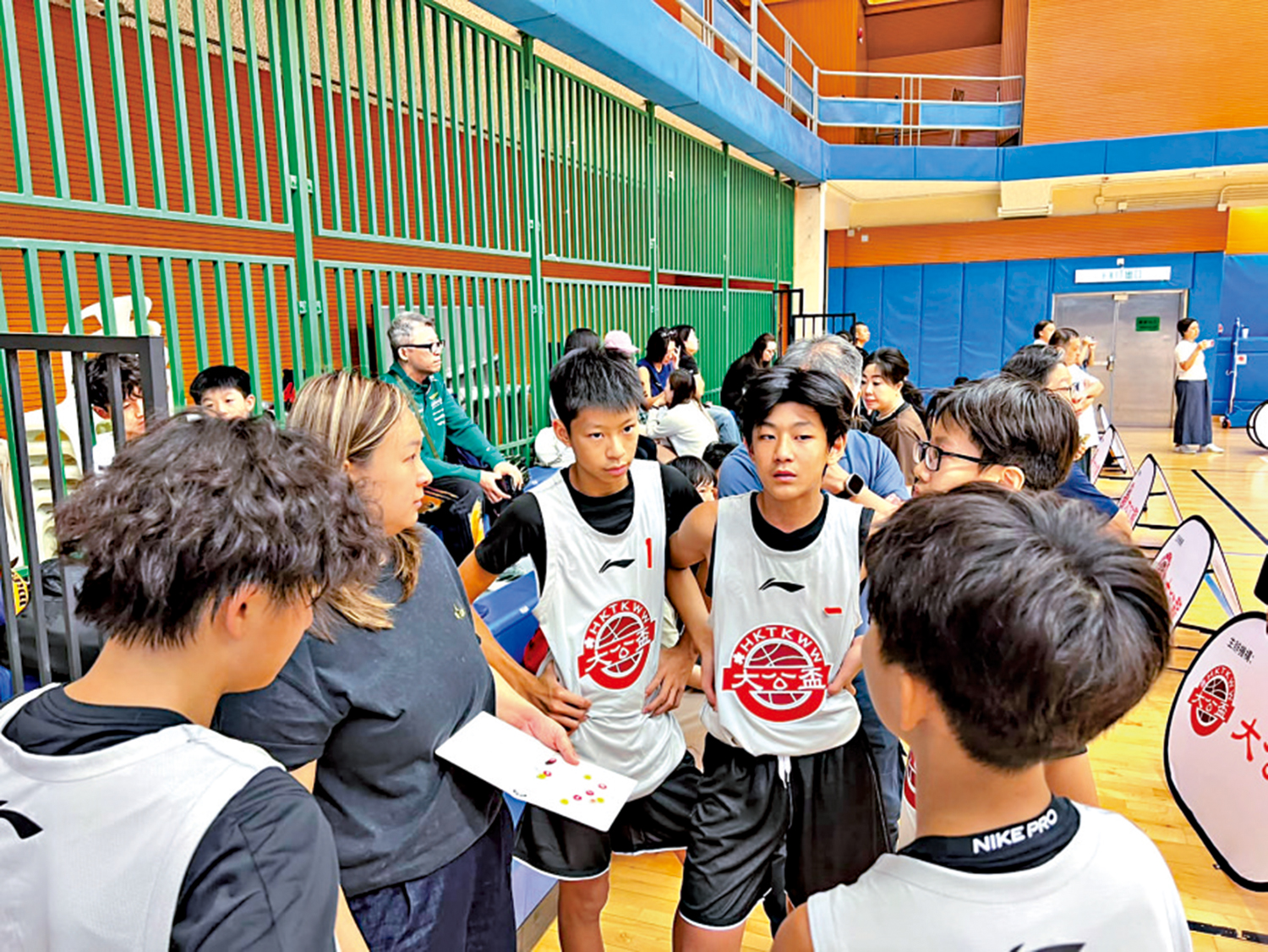　　圖：教練在賽事暫停期間，手持戰術板向球員講解新部署。\大公報記者朱家立攝