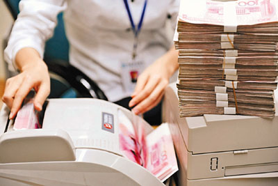 　■報道指，中國可能會將2011年新增貸款目標定為至少7萬億元。圖為銀行職員在清點人民幣。新華社
