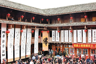 　■書法大師林志良的巨幅作品懸掛土樓牆上。香港文匯報記者米南  攝 