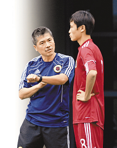 　■曾偉忠和青年球員細心論戰。香港文匯報記者潘志南 攝