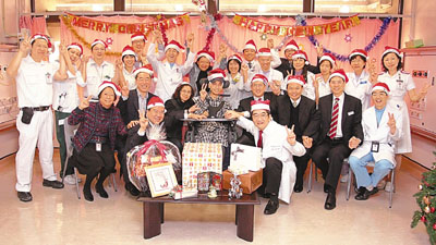 　■政務司司長唐英年聯同食物及衛生局局長周一嶽、醫院管理局主席胡定旭和行政總裁梁柏賢到屯門醫院探訪梁頌學，慶祝聖誕，並與梁太、方道生醫生及醫護人員合照。