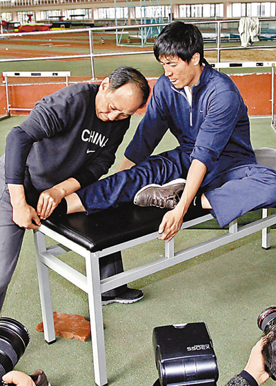 　■孫海平(左)為劉翔受傷的右腳進行拉筋訓練。	資料圖片