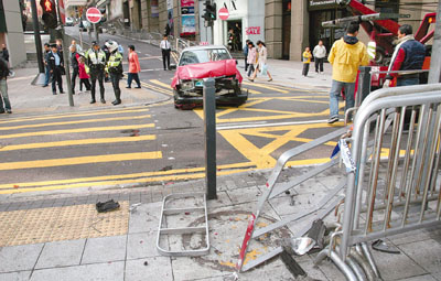 　■雲咸街直衝而下撼向行人路鐵欄的肇事的士車頭嚴重毀爛。	香港文匯報記者溫瑞麟  攝