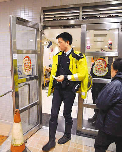 　■警員到場調查險塌下的大鋼門(左)。