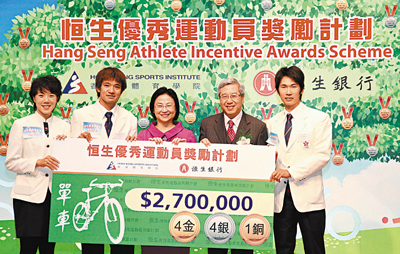 單車隊在亞運會中取得4金4銀及1銅佳績，獲頒2,700,000港元現金獎勵，成為港隊之冠。�琤芼�行副董事長兼行政總裁梁高美懿女士（中）及香港體育學院主席李家祥博士（右2）頒發支票予單車隊隊員。 