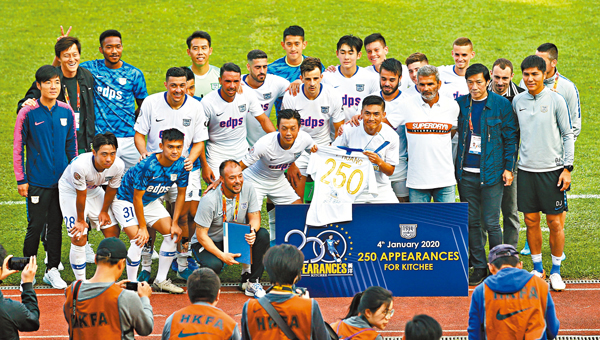 ■ 眾隊友恭賀黃洋（手持T恤者）為球會上陣250場比賽。 香港文匯報記者黎永淦  攝