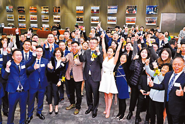 ■九毛九主席兼行政總裁管毅宏和家人及公司員工慶祝上市成功。  中新社