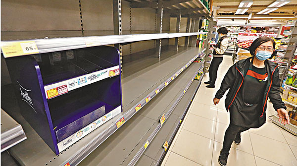 ■市民把超級巿場貨架上的廁紙搶空。 香港文匯報記者  攝