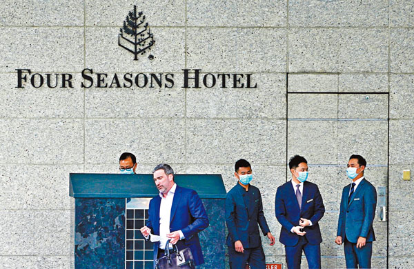 ■工聯會轄下酒店及餐飲從業員協會要求，酒店必須為員工提供足夠及具規格防護措施減少感染風險。圖為香港四季酒店員工戴上口罩迎賓。 資料圖片
