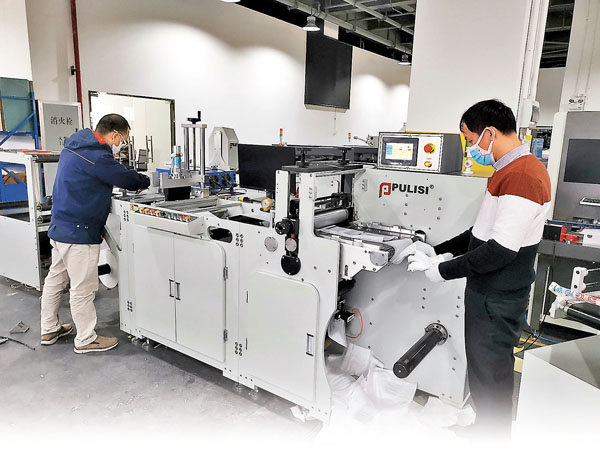 ■廣州普理司科技公司技術人員調試全新研發的AI全自動口罩機。  受訪者供圖