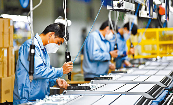 ■ 政治局要求要在確保做好防疫工作的前提下，有序推動各類企業復工復產。圖為廣州創維平面顯示科技有限公司生產車間的工人佩戴口罩作業。 新華社