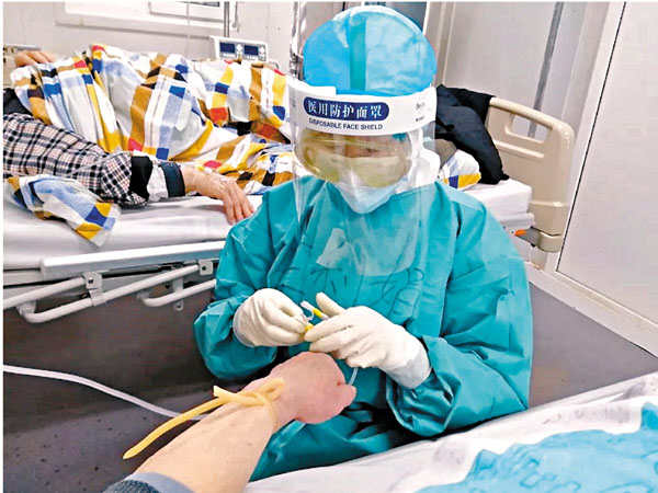 ■ 王利娟身穿嚴密的防護裝備，為患者扎針。受訪者供圖