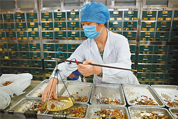 ■ 內地官方發佈最新版新冠肺炎診療方案，增加對危重症病患的中醫藥治療方法。圖為北京地壇醫院中醫藥藥師在配置藥物。 中新社