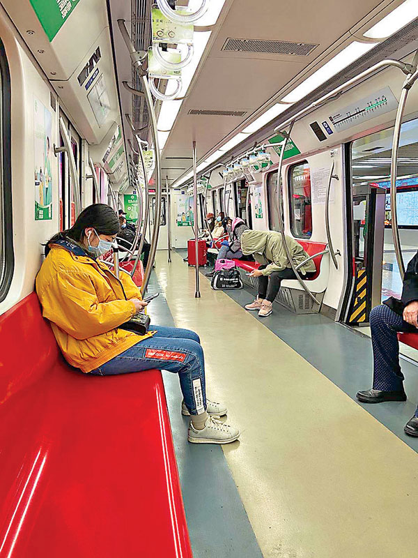 ■地鐵車廂內，乘客都佩戴口罩且間隔而坐。 香港文匯報記者李理 攝