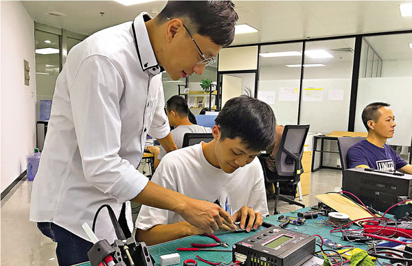 ■香港創業青年梁子斌（左）表示，新政破解了融資難題。圖為梁子斌團隊在開展產品研發。 敖敏輝  攝