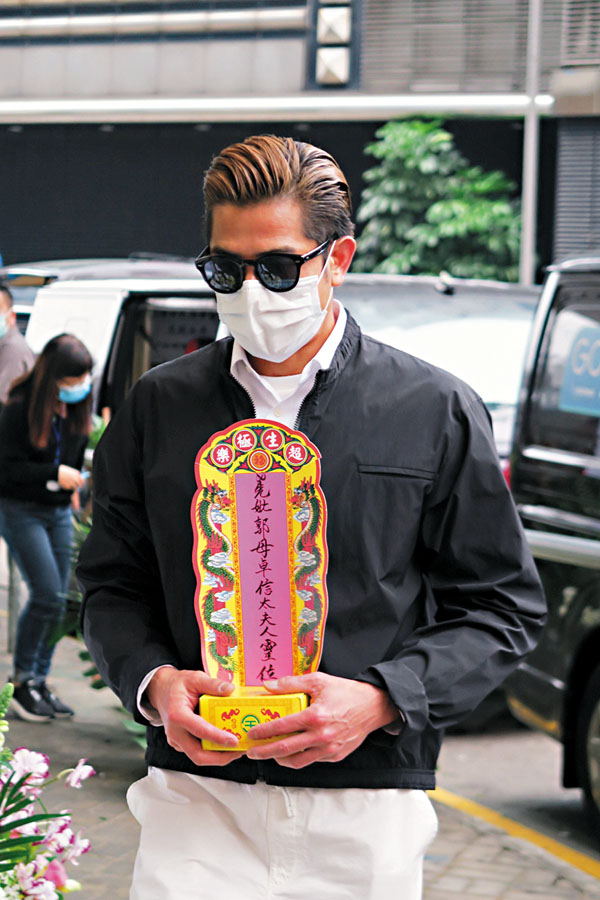 ■ 雙手捧�茈擦侔F位牌的城城，神情木訥。