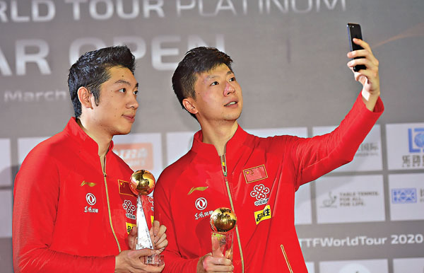 ■ 馬龍（右）和許昕在頒獎台上自拍。  新華社