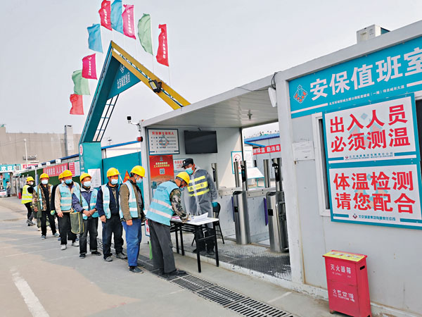 ■施工人員排隊進行體溫測量登記。 香港文匯報記者張帥  攝