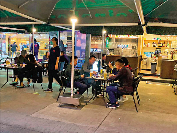 ■酒吧關停令昨日生效後，持有「「酒吧及餐廳」牌照的酒吧即時變身為食肆繼續營業，並仍以賣酒為主。圖中所見幾乎每�^都有顧客買醉。香港文匯報記者  攝