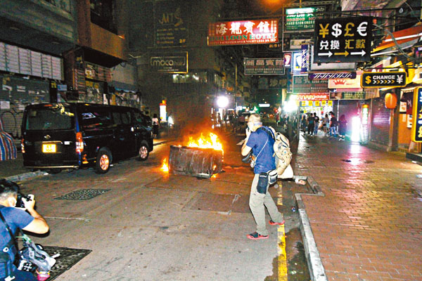 ■黑衣魔在西洋菜街縱火燒垃圾桶。 香港文匯報記者  攝