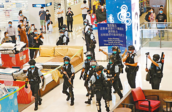 ■防暴警在將軍澳東港城多次舉「藍旗」警告聚集人群散去。 香港文匯報記者  攝