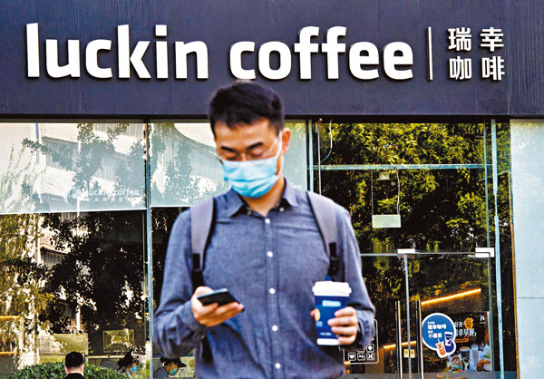 ■一位市民經過瑞幸咖啡位於北京市朝陽區寶能中心的一家門店。中新社