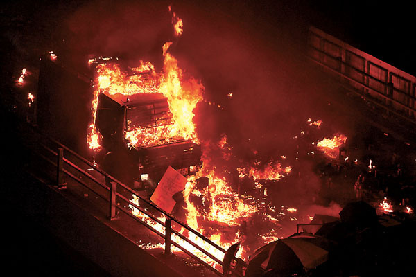 ■ 去年11月17日晚， 理工大學附近的暴徒向警方防線投擲燃燒彈，裝甲車�茪鶠C  資料圖片