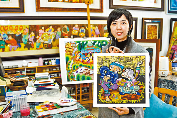 ■農民版畫師黃袁媛展示她創作的綦江農民版畫作品。