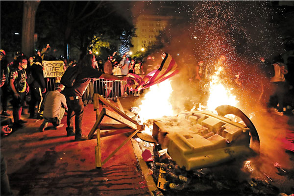 ■示威者在白宮外焚燒美國旗及雜物。 美聯社
