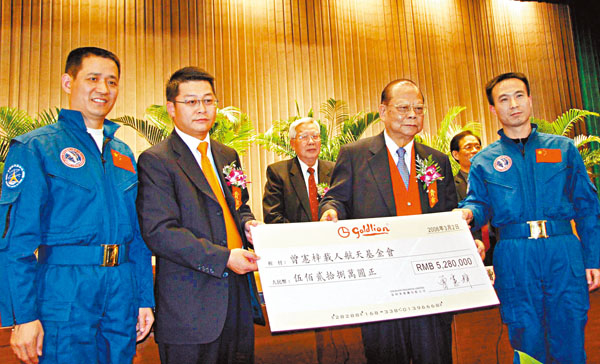 ■ 2006年3月2日，曾憲梓先生在北京向神舟六號兩位英雄太空人費俊龍、聶海勝頒發特別貢獻獎。 資料圖片