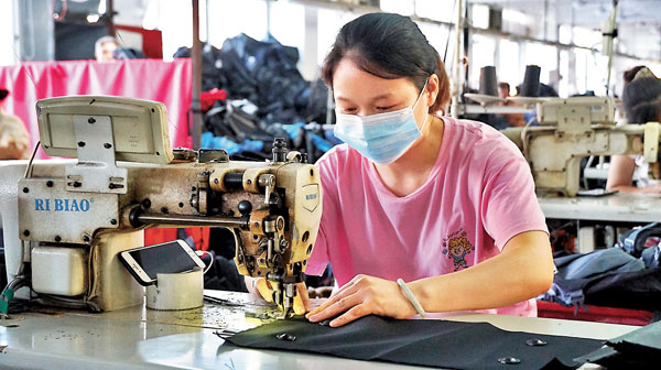 ■ 福建泉州豐澤區的某箱包加工廠內，工人正趕製出口歐洲的包袋。香港文匯報記者蔣煌基  攝