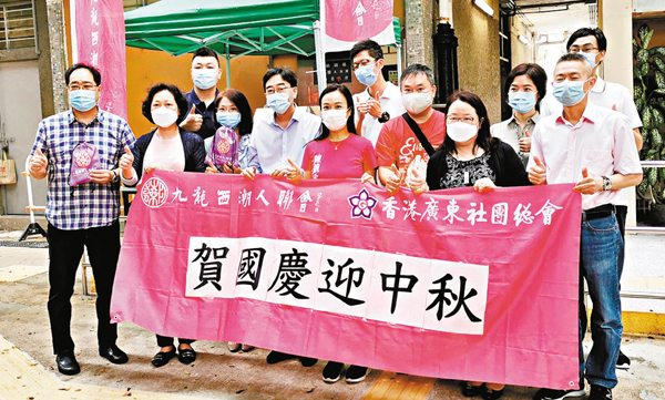 ■高永文和陳凱欣參加九西潮聯的社區送暖活動，向居民派發月餅和口罩。 香港文匯報記者  攝