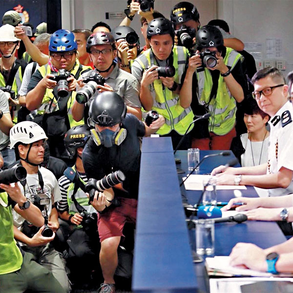 ■去年6月13日，大批記者在警方記者會上「戴頭盔」稱要抗議「警暴」。 資料圖片