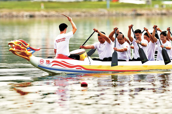 ■奧運冠軍孟關良（一排左）、楊文軍（一排右）與隊友一起對競技龍舟進行下水測試。 中新社