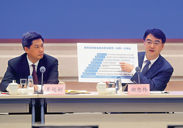 ■國家衞生健康委醫藥衞生科技發展中心主任鄭忠偉展示「新型冠狀病毒疫苗緊急使用（試用）大事記」展板。  中新社