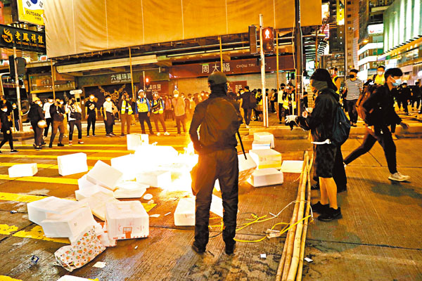 ■一名運動用品店採購經理和一名荷蘭籍幼稚園教師，涉嫌今年2月29日晚於旺角撕書放入垃圾桶燃燒，昨日各被判監禁4個月。圖為當晚有暴徒於旺角街頭堵路及縱火。 資料圖片