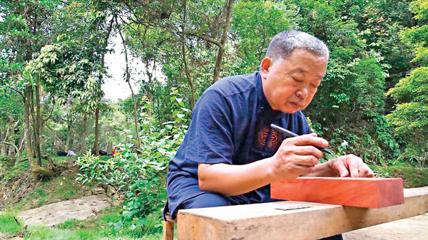 ■王德文在木料上畫線。