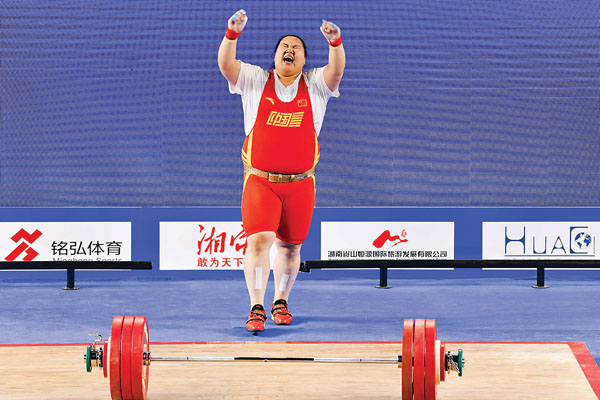 ■李雯雯在挺舉比賽中慶祝。  新華社