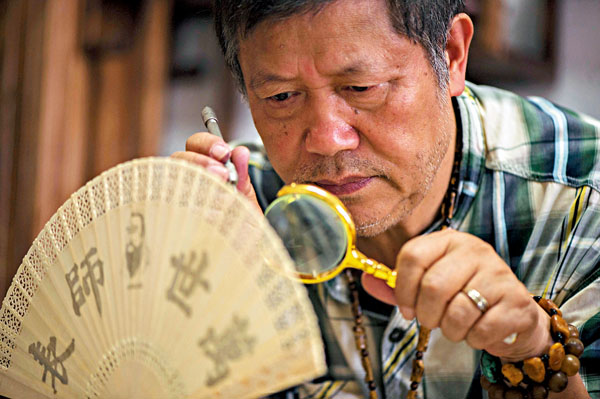 ■潘啟慧與微刻作品「萬世師表」。